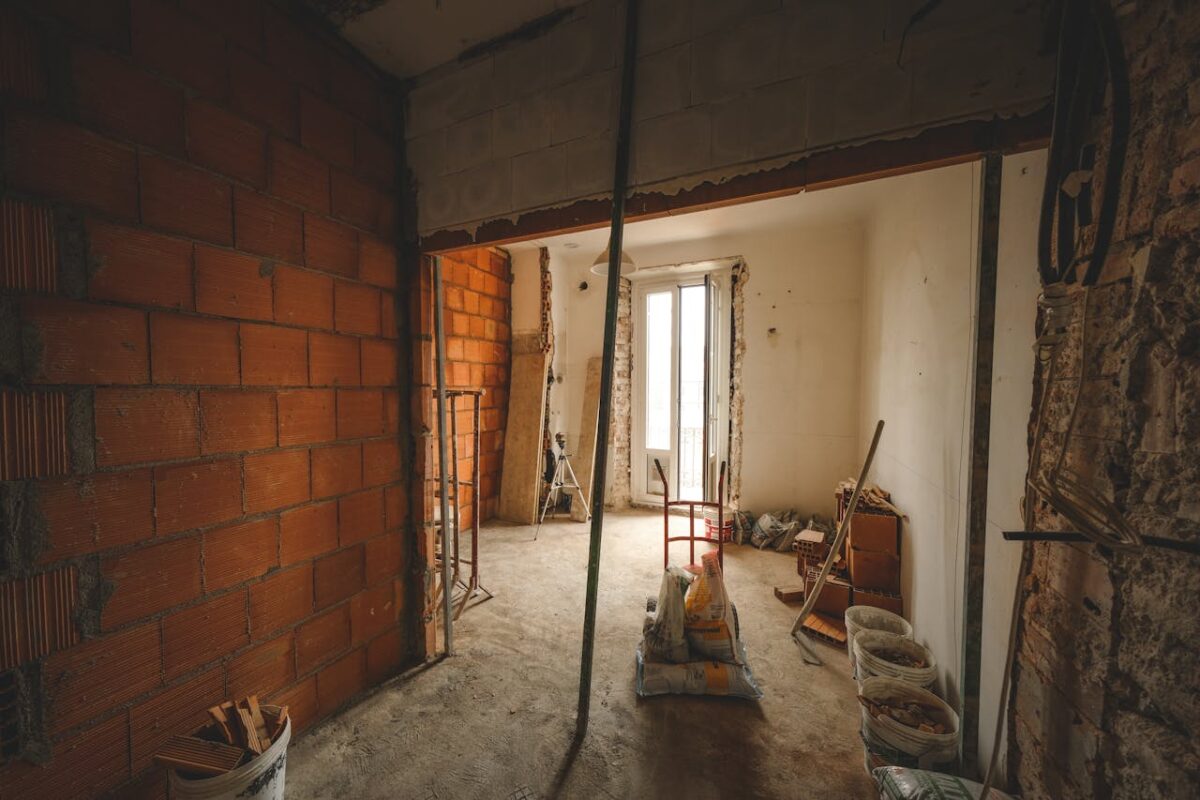 A partially renovated room with exposed brick walls and construction materials on site.