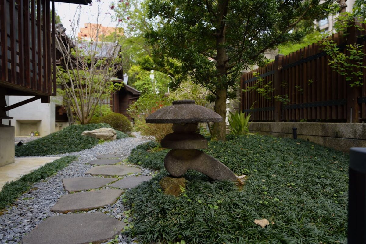 Tranquil stone path and lantern in a lush Japanese garden in Taipei.