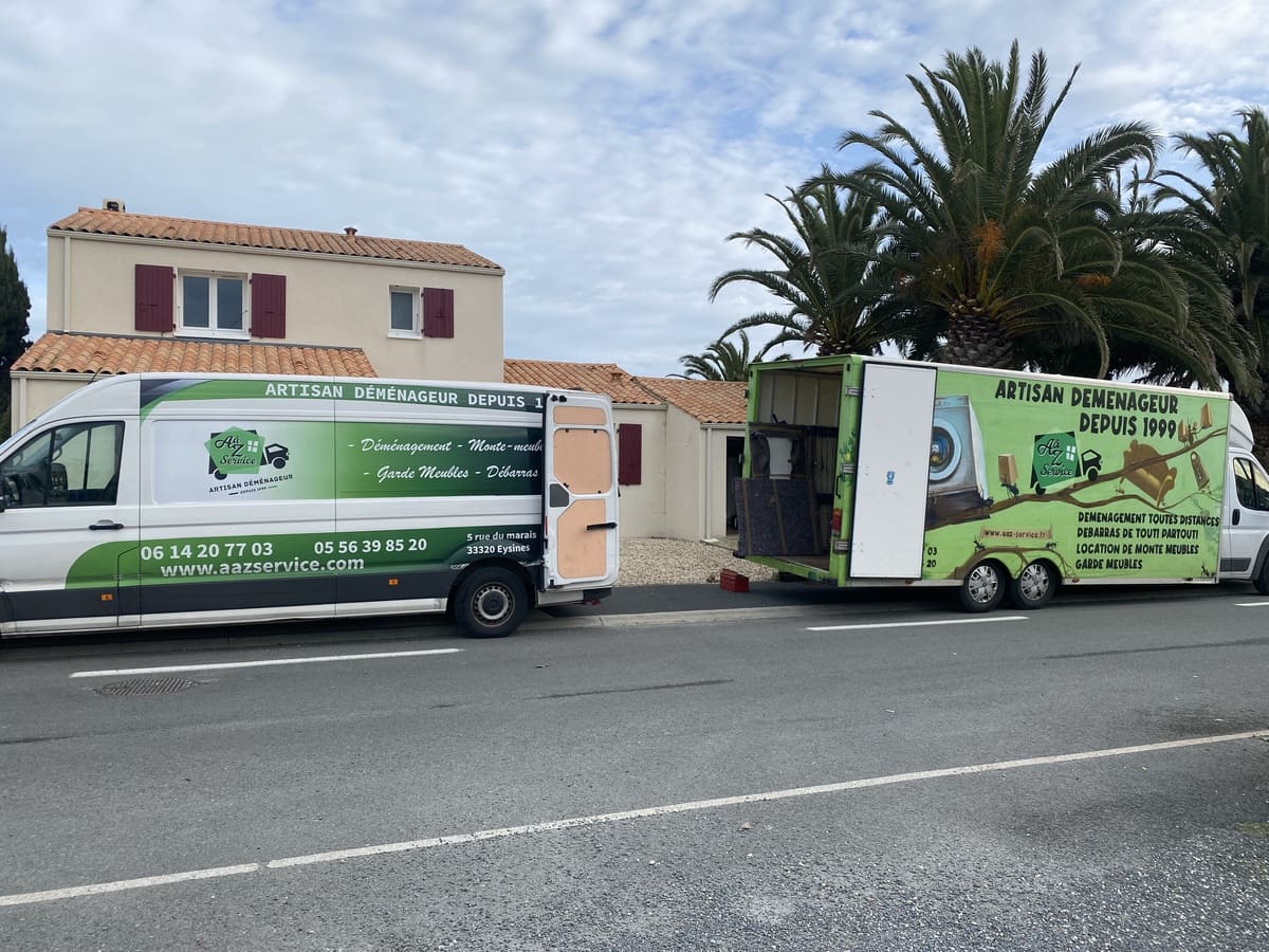 Deux camions de déménagement devant un pavillon